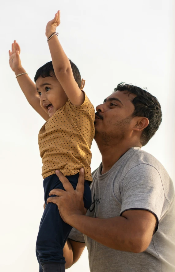 A parent lifting their child joyfully
